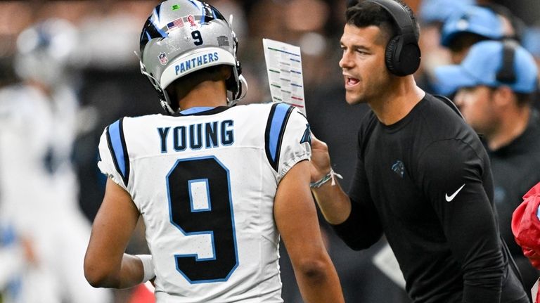 Carolina Panthers head coach Dave Canales right talks to quarterback...