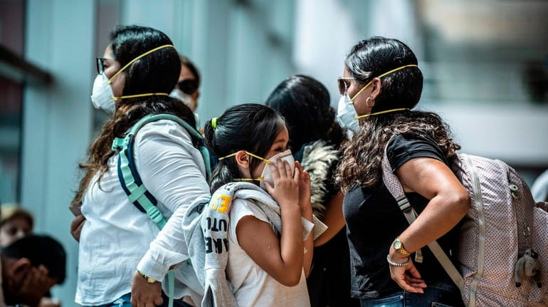 Travelers wear protective masks at Jorge Chavez International Airport in Lima last week.
