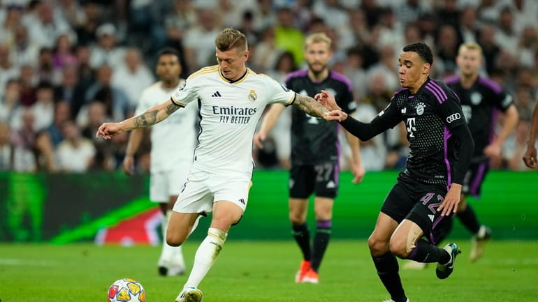 Real Madrid's Toni Kroos, left, challenges for the ball with...