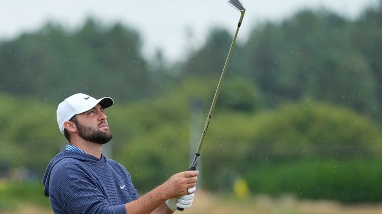 Scottie Scheffler of the United States looks at his club...