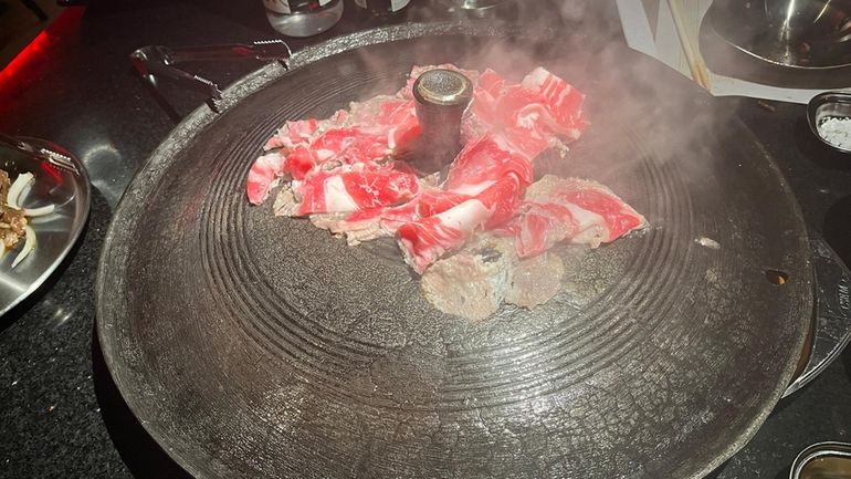 Beef brisket cooked in an oversized cast iron pot at Won...