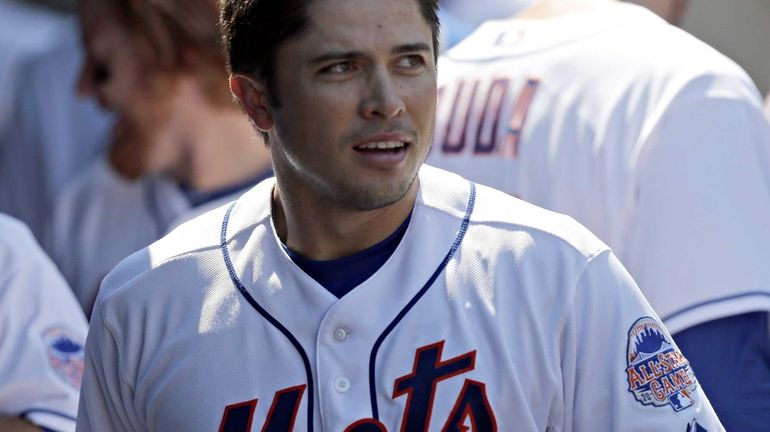 Travis d'Arnaud (15) looks on in the dugout in the...