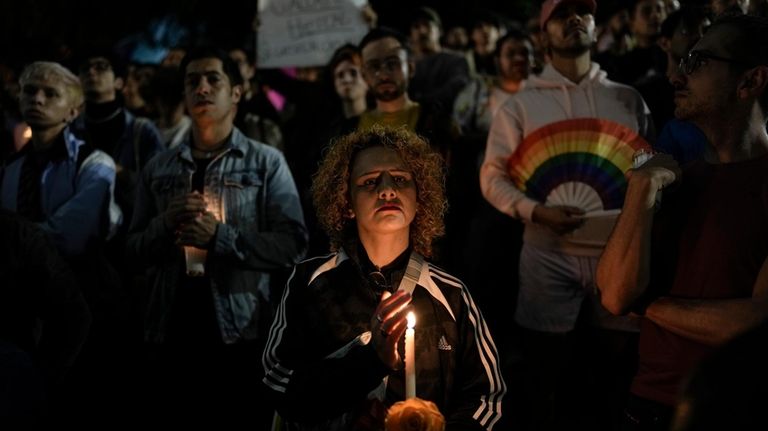 A demonstrator holds a candle during a protest in Mexico...