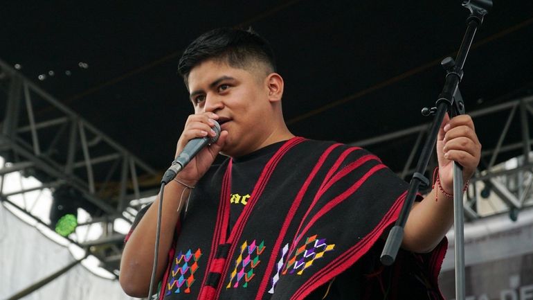 Mexican-Triqui artist Carlos CGH, wearing a black and red “gabán,”...