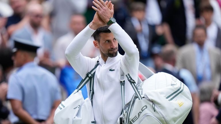 Novak Djokovic of Serbia waves as he leaves Centre Court...