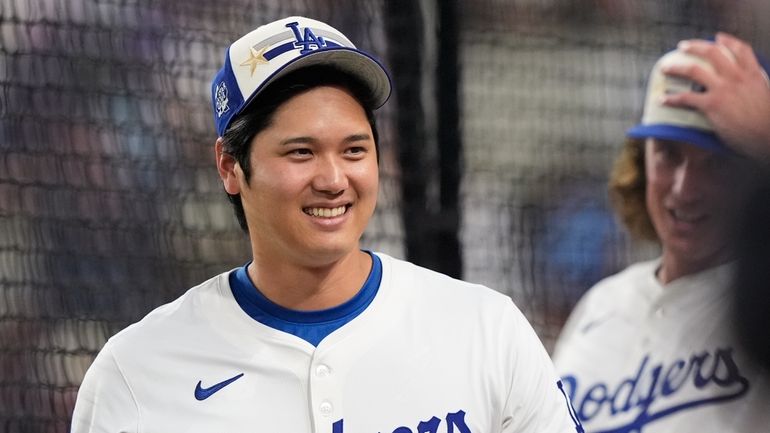 National League's Shohei Ohtani, of the Los Angeles Dodgers, smiles...