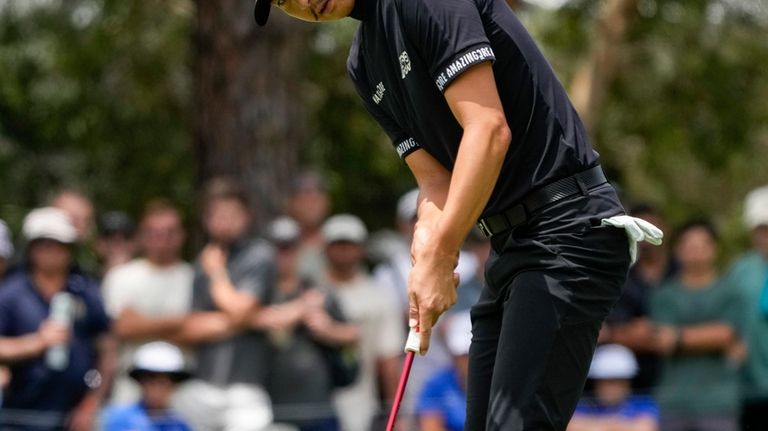 Australia's Min Woo Lee watches his putt on the second...