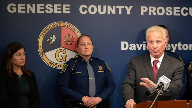Genesee County Prosecutor David Leyton speaks, alongside Michigan State Police...