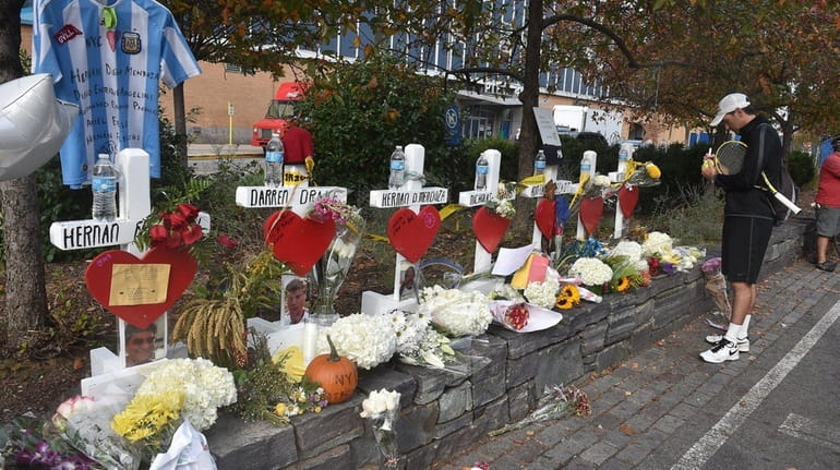 A visitor pays his respects at a makeshift memorial along...