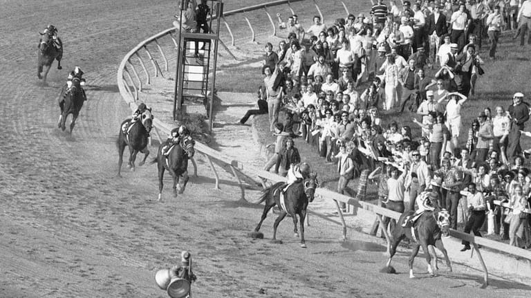 Secretariat, right, leads the field coming out of the final...