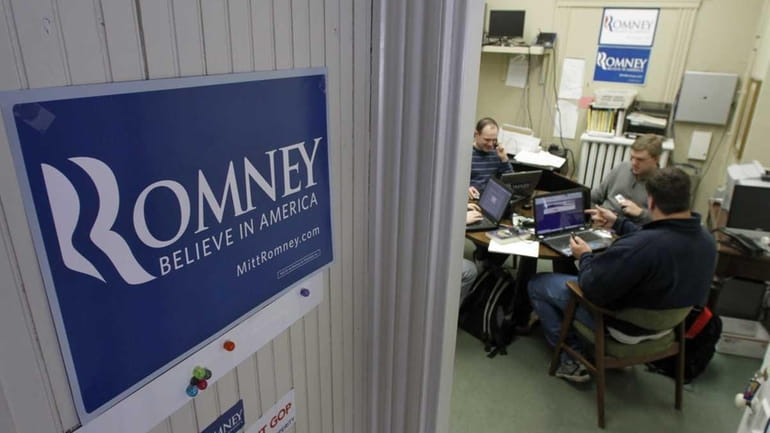 Campaign workers man the phones at the Romney headquarters in...