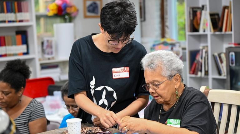 Kris Waymire, a Ma's House artist-in-residence, teaches beadwork to Miriam...