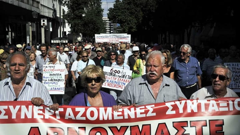 Pensioners carry a banner, reading: "We refuse to pay the...