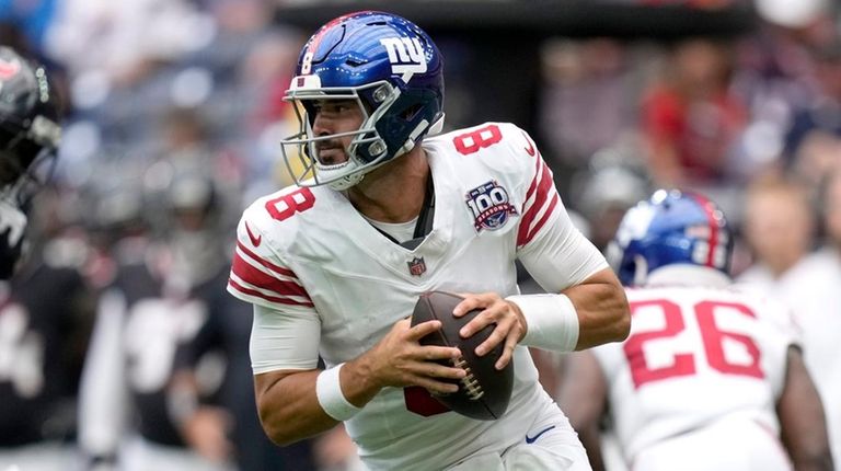 Giants quarterback Daniel Jones rolls out of the pocket before...