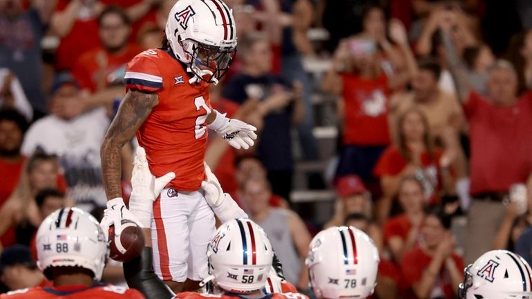 Arizona wide receiver Jeremiah Patterson (2) is hoisted in the...