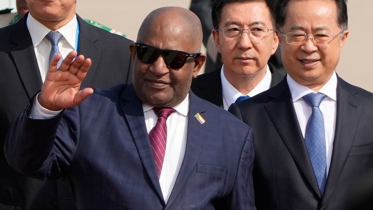 Comoros' President Azali Assoumani waves as he is escorted by...