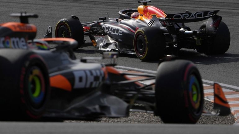 Red Bull driver Max Verstappen of the Netherlands, right, steers...