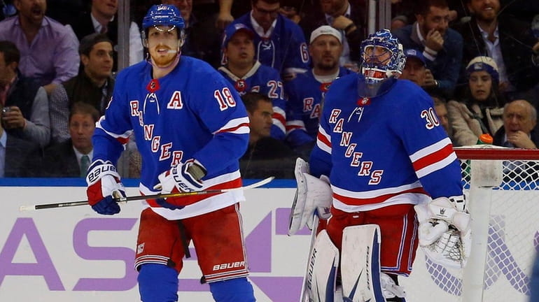 The Rangers' Henrik Lundqvist and Marc Staal look on after...