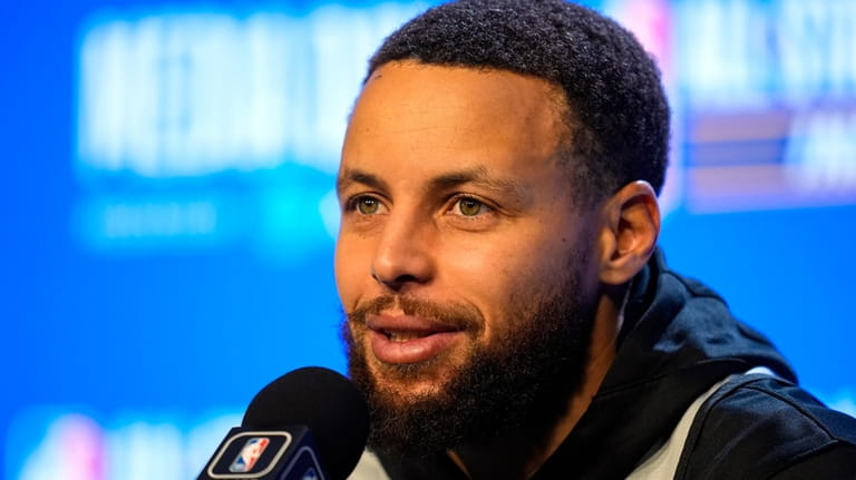 Golden State Warriors guard Stephen Curry answers a question during...