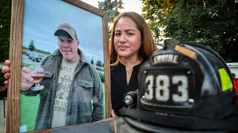 Mariuxy Mora holds a portrait of her late husband, Yaphank...