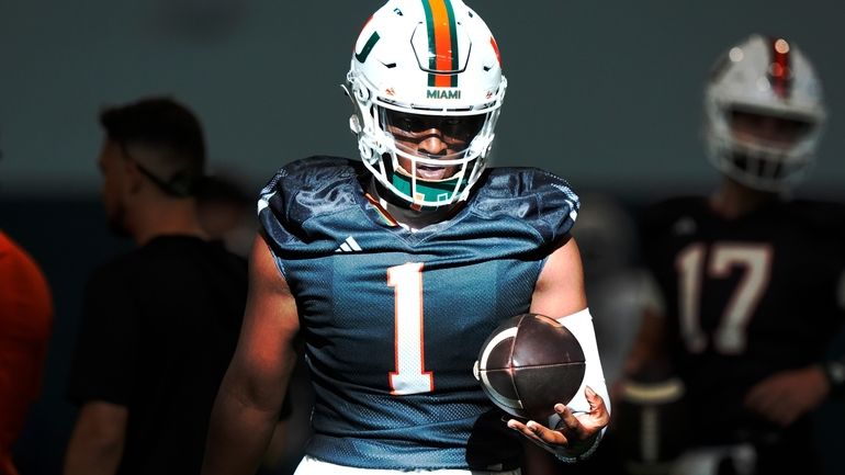 Miami quarterback Cam Ward (1) holds the ball during NCAA...