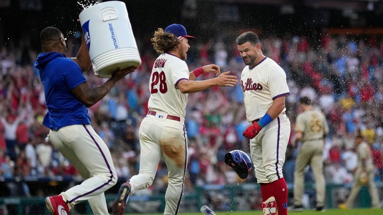 Philadelphia Phillies' Kyle Schwarber, right, celebrates with Alec Bohm, center,...