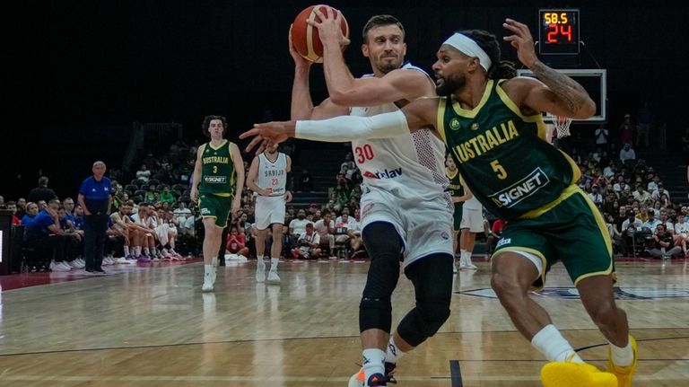 Serbia's Aleksa Avramovic, left, drives to the basket as Australia's...