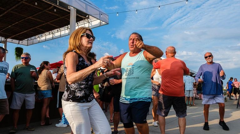 Nancy and Steve Busa, of St. James, dance to the...