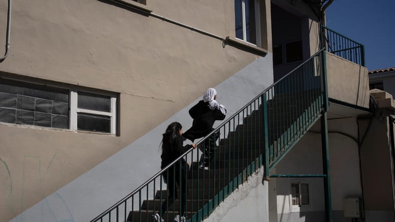 Students run up a flight of stairs as they make...