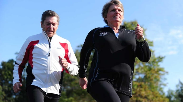 Portrait of Dorene Schneider, right, along with her running coach,...