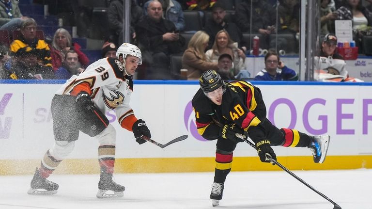 Vancouver Canucks' Elias Pettersson (40) reaches for the puck after...