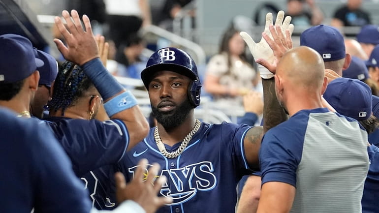 Tampa Bay Rays' Randy Arozarena is high-fived in the dugout...
