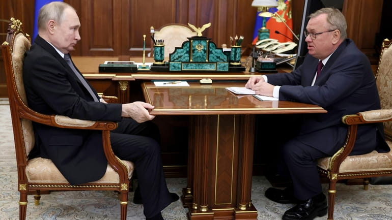 Russian President Vladimir Putin, left, listens to VTB Bank Chairman...