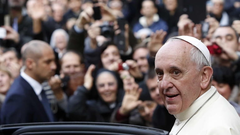 Pope Francis smiles as he leaves Rome's Jesus' Church to...