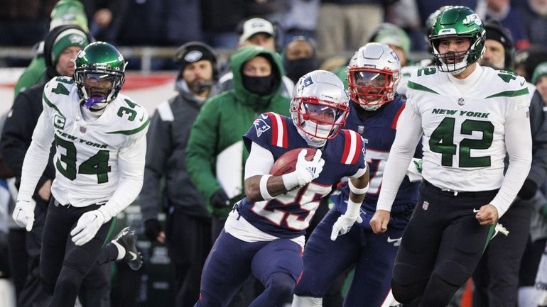 Patriots cornerback Marcus Jones outruns Jets safety Jordan Whitehead, left, and long snapper...