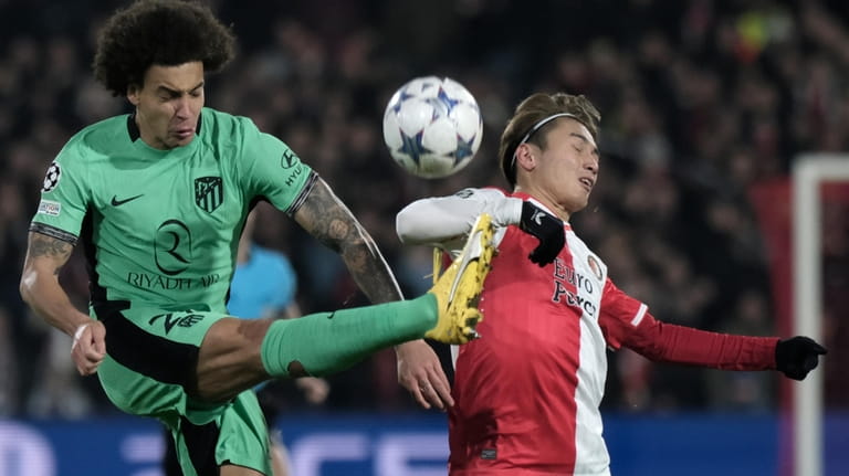 Feyenoord's Ayase Ueda, right, challenges Atletico Madrid's Axel Witsel during...