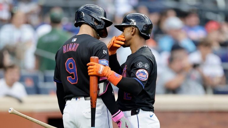 Francisco Lindor of the Mets talks to Brandon Nimmo after batting...