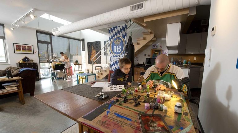 Jim Richards helps his son Connor, 10, on a project,...