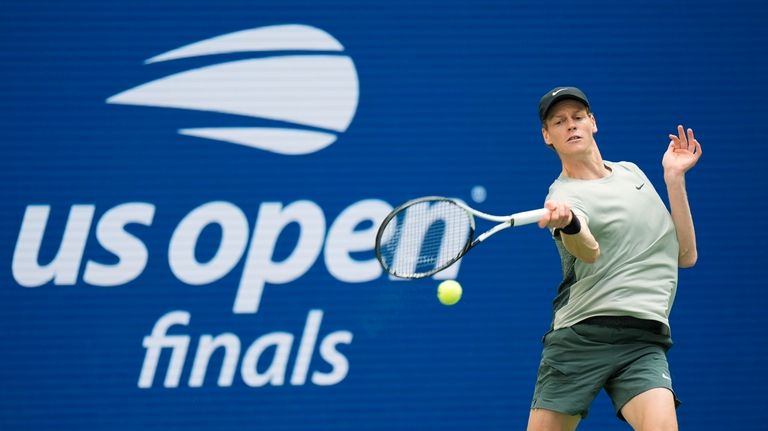 Jannik Sinner, of Italy, returns a shot to Taylor Fritz,...