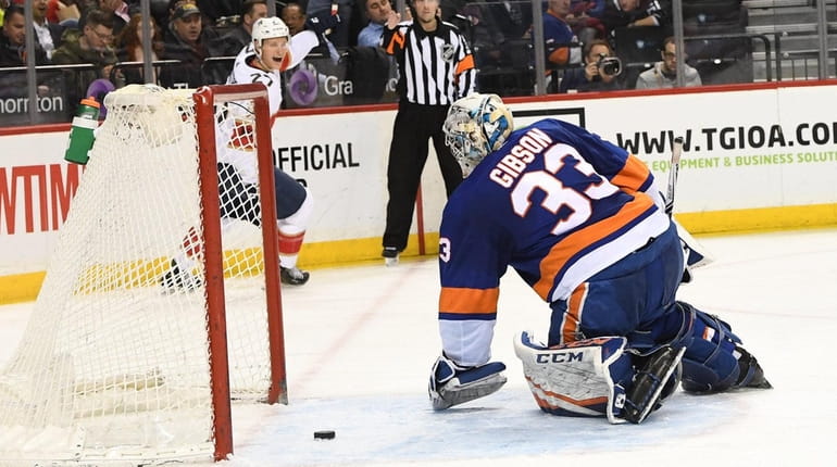 Islanders goaltender Christopher Gibson kneels in front of the net...