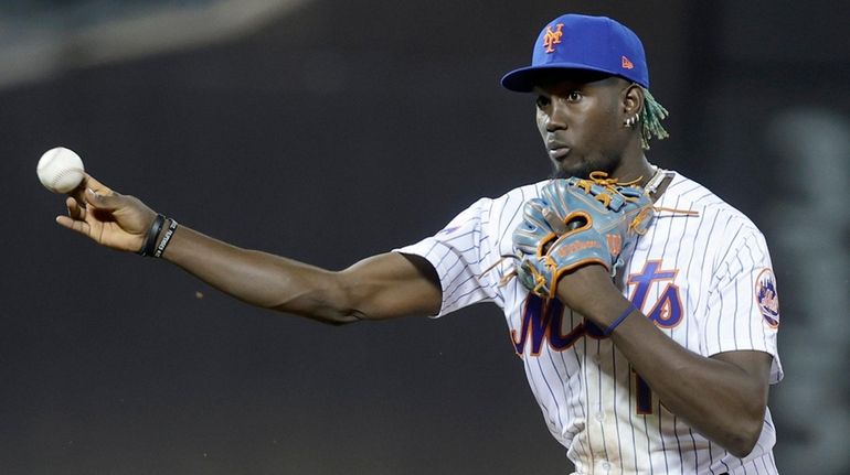 Ronny Mauricio of the Mets throws to first base against the Mariners...