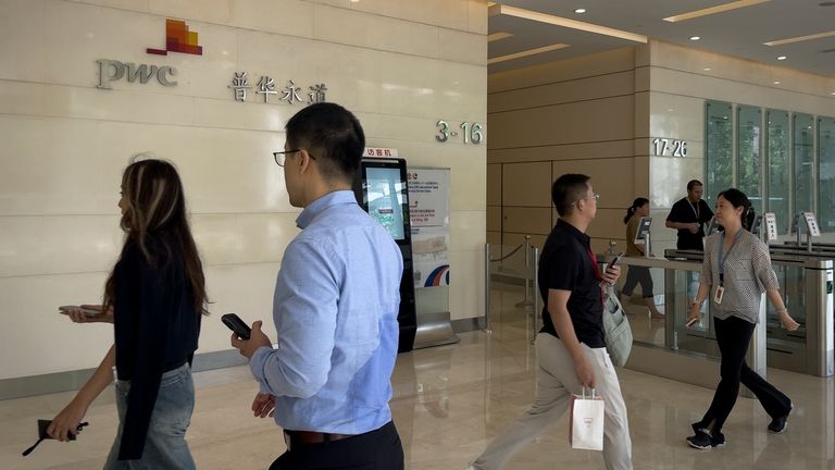 People walk by the audit firm PricewaterhouseCoopers (PWC) office at...