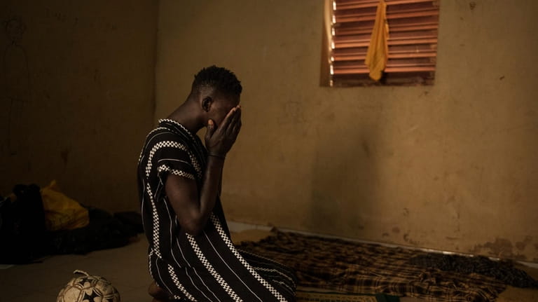 Papa Dieye, 19, prays in his father’s home in Diogo,...