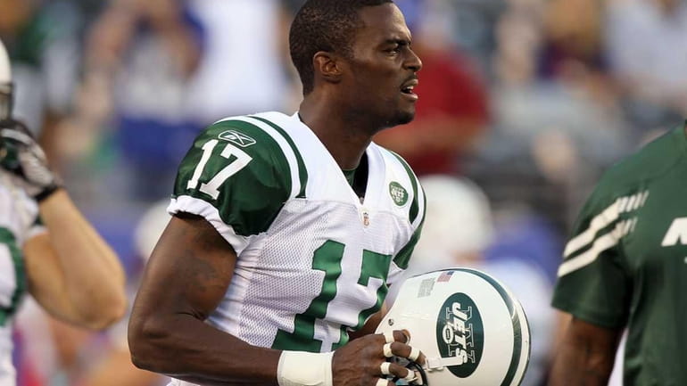 Plaxico Burress of the New York Jets warms up before...
