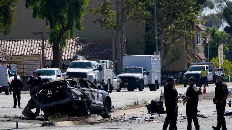 A charred police vehicle is seen in aftermath of an...