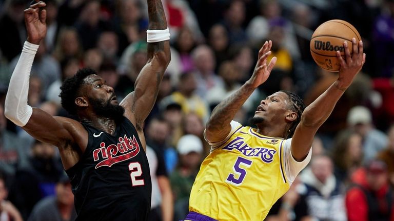 Los Angeles Lakers forward Cam Reddish shoots against Portland Trail...