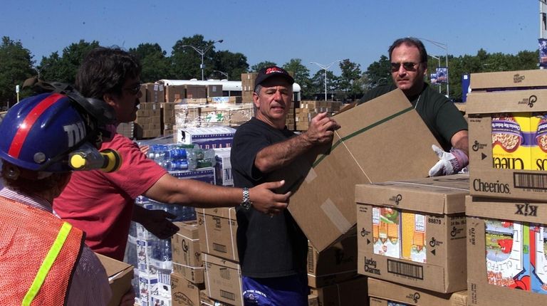 Mets manager Bobby Valentine in the center helping workers with boxes...