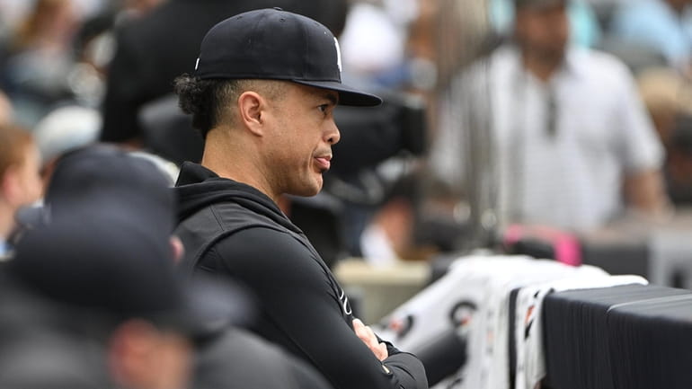 The Yankees’ Giancarlo Stanton looks on from the dugout during...