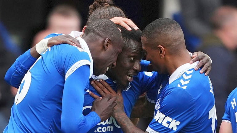 Everton's Idrissa Gueye, center, celebrates scoring with teammates during the...