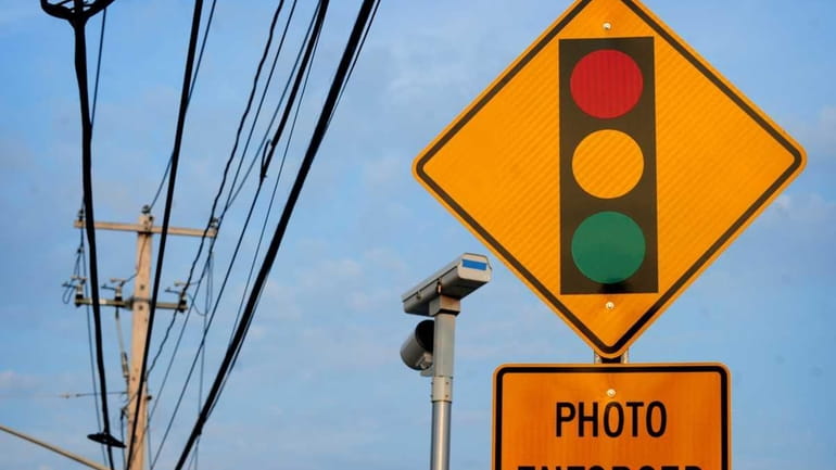 A sign and red-light camera on Middle Country Road near...